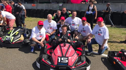 Red kart with a team of people behind